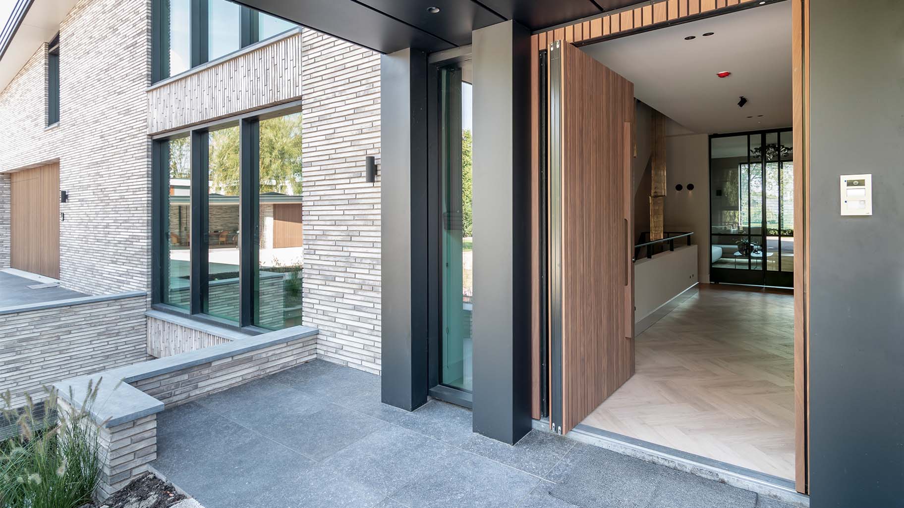 Houten taatsdeur als voordeur van een moderne woning