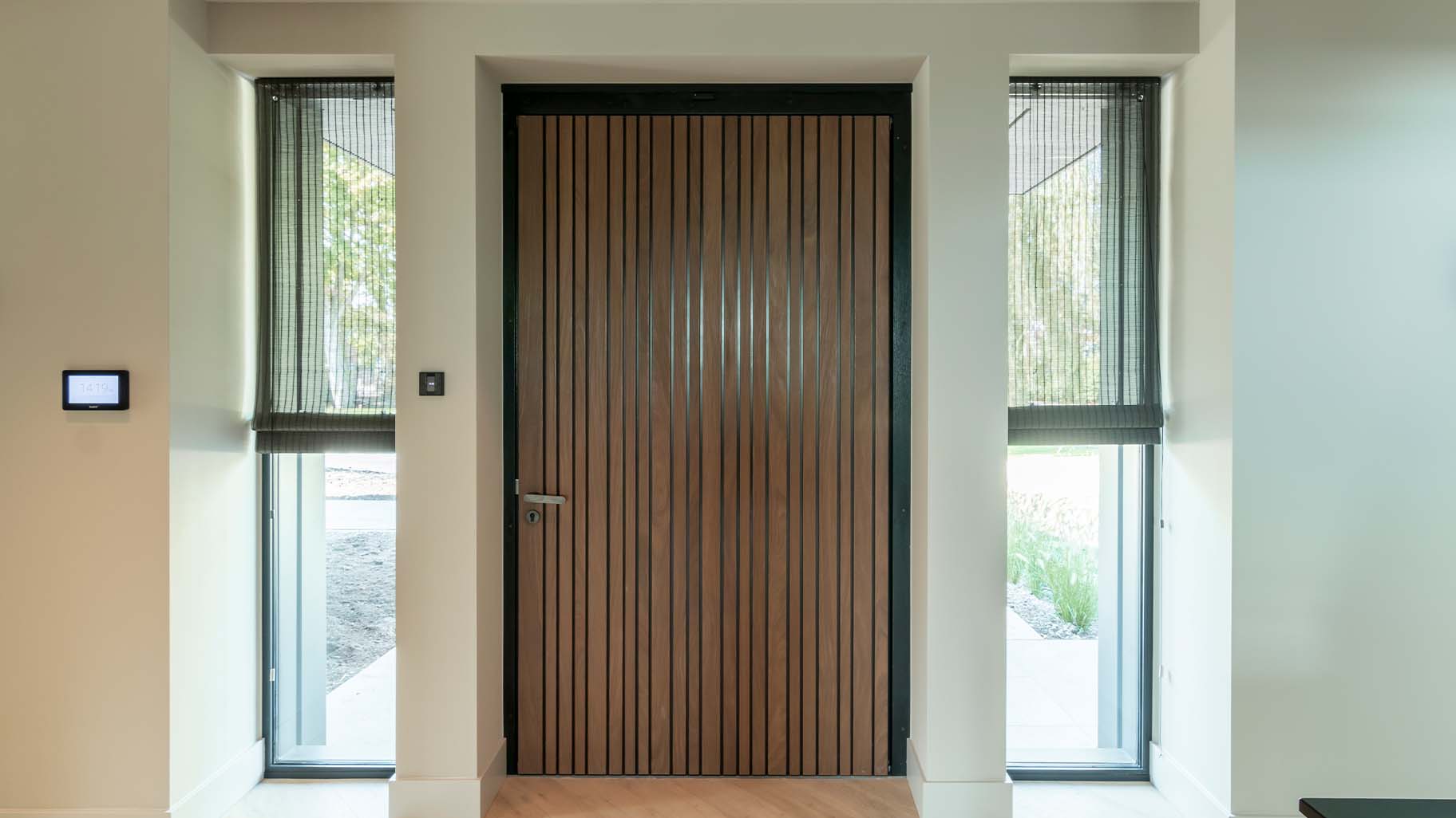 Houten taatsdeur als voordeur van een moderne woning