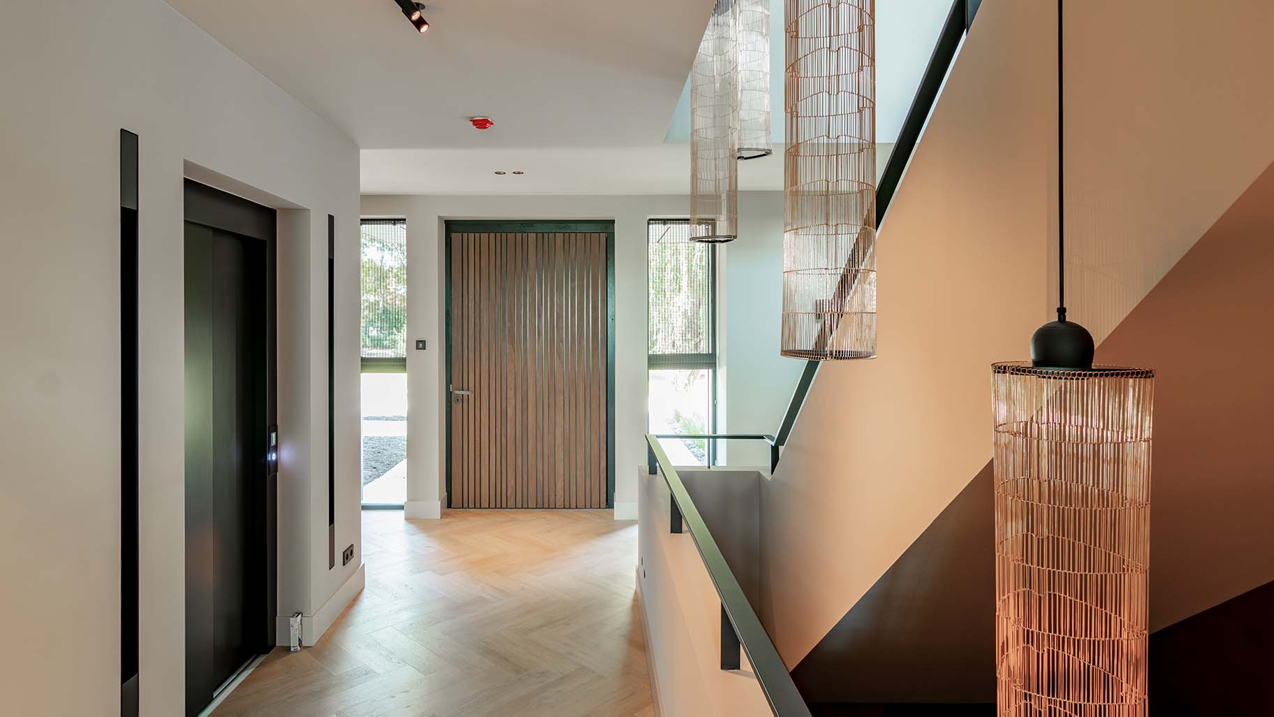 Houten taatsdeur en garagedeur geïntegreerd in de gevel