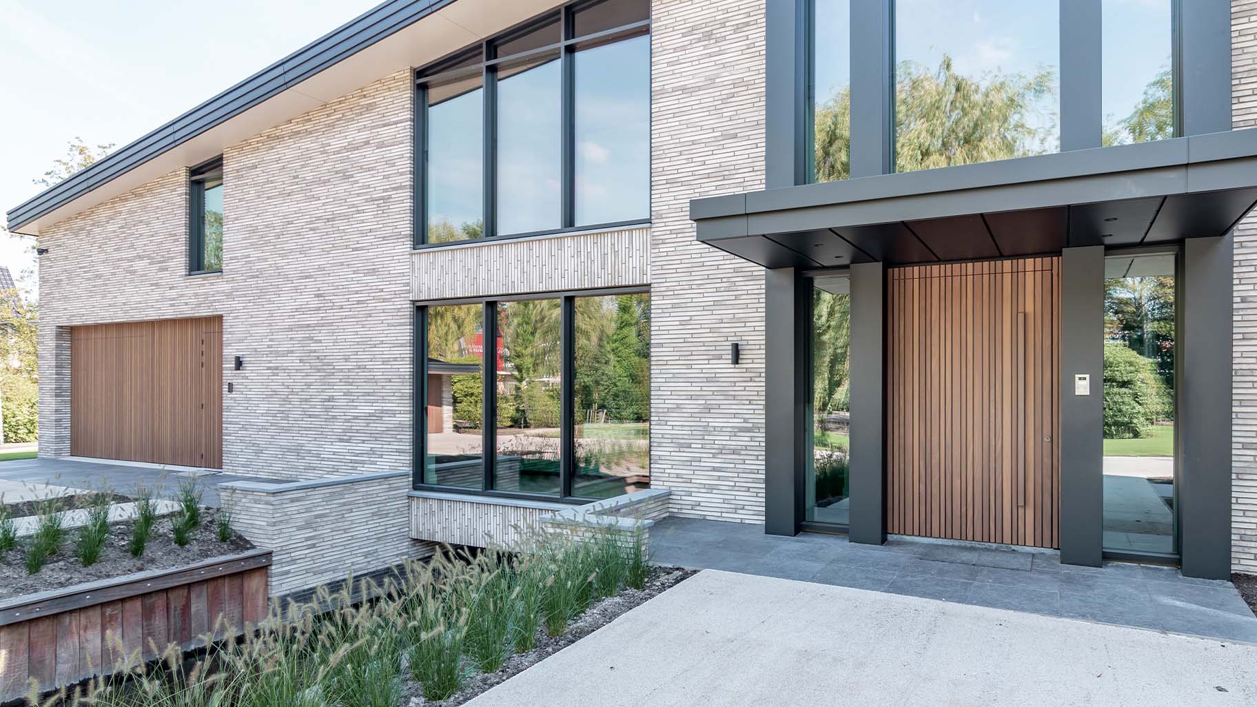 Houten taatsdeur en garagedeur geïntegreerd in de gevel