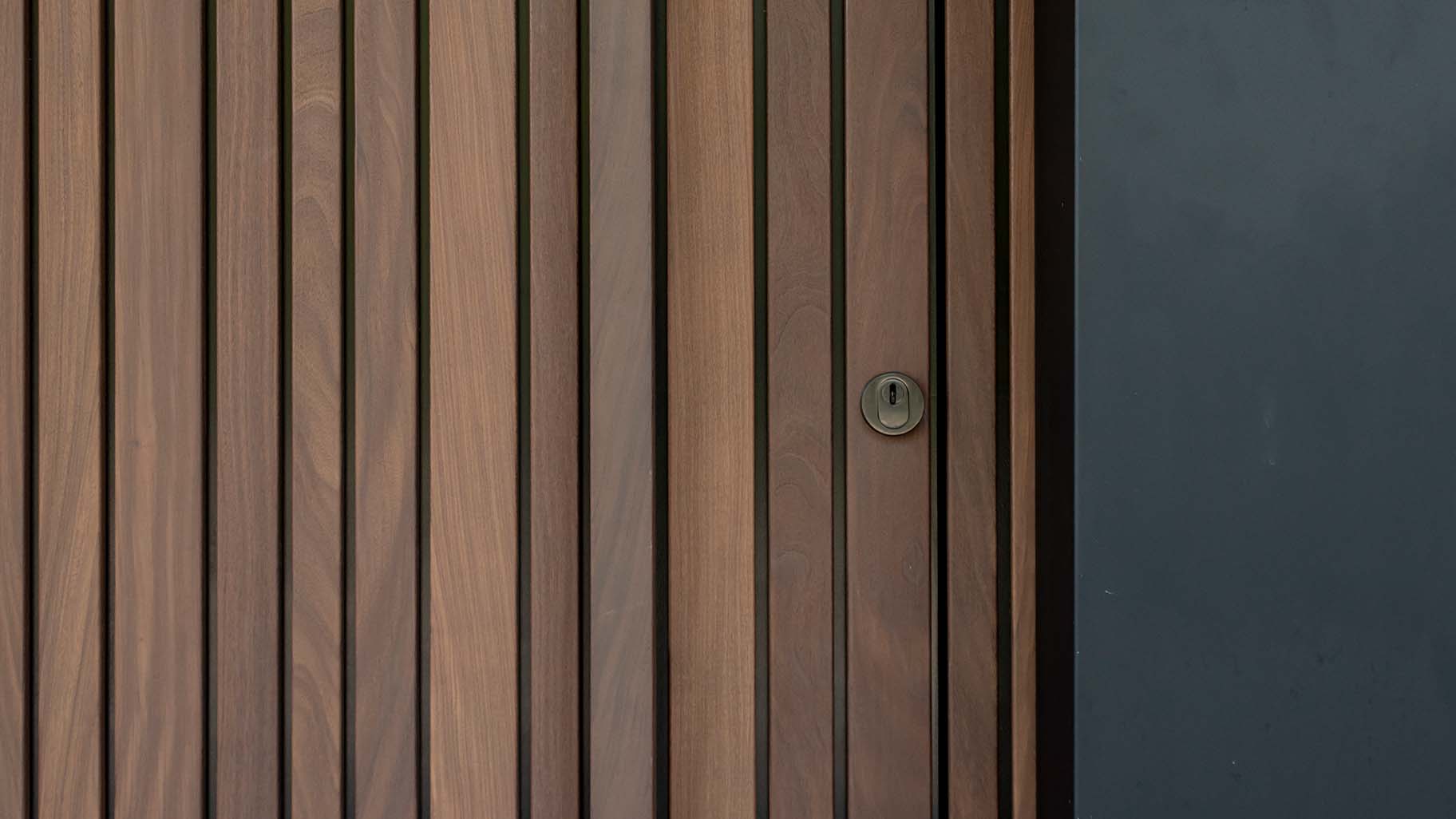 Houten taatsdeur en garagedeur geïntegreerd in de gevel