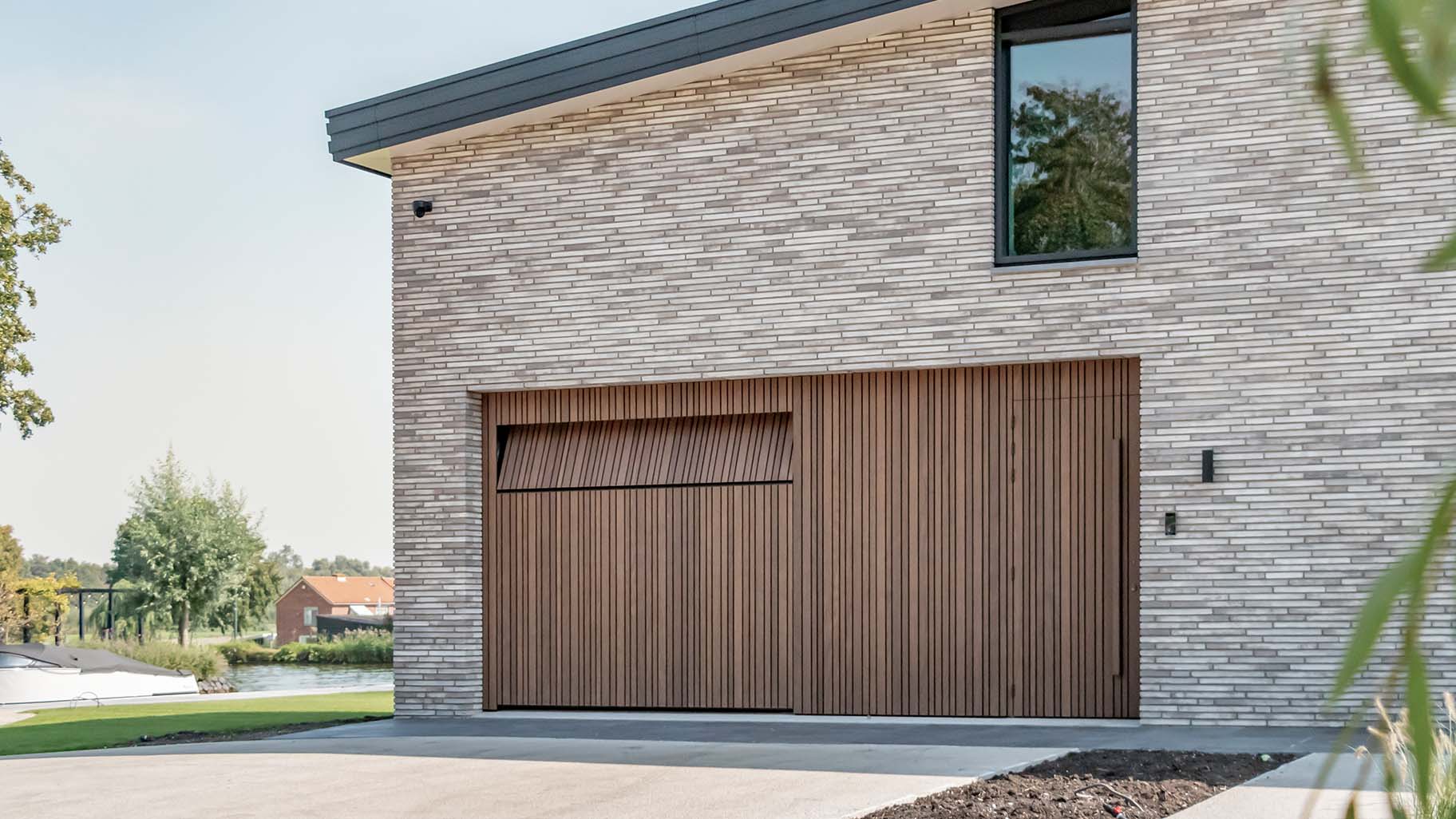 Houten garagedeuren met loopdeur, handig verwerkt in de voorgevel