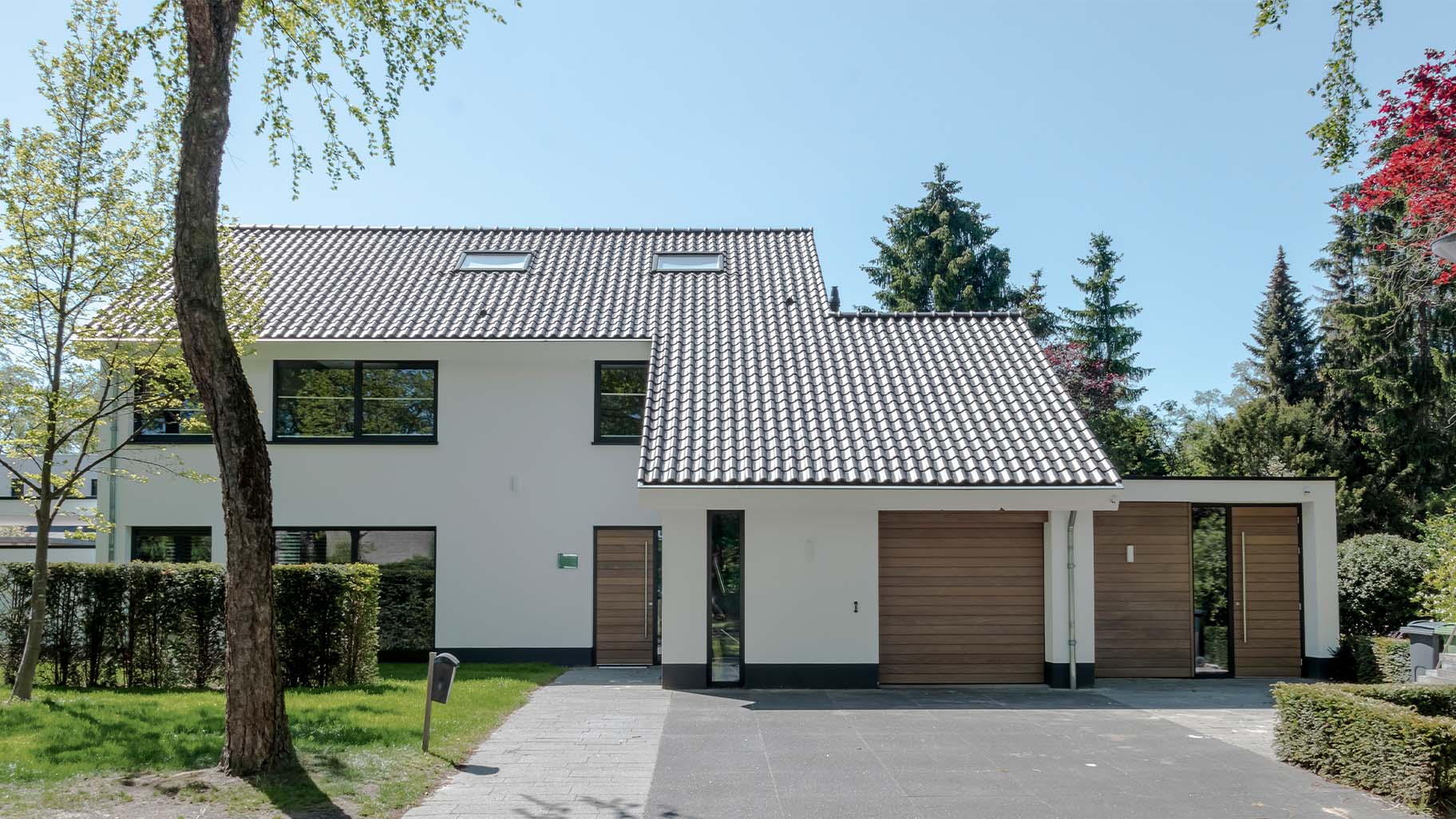 Different Doors houten sectionaaldeur bij gerenoveerde jaren '70 villa