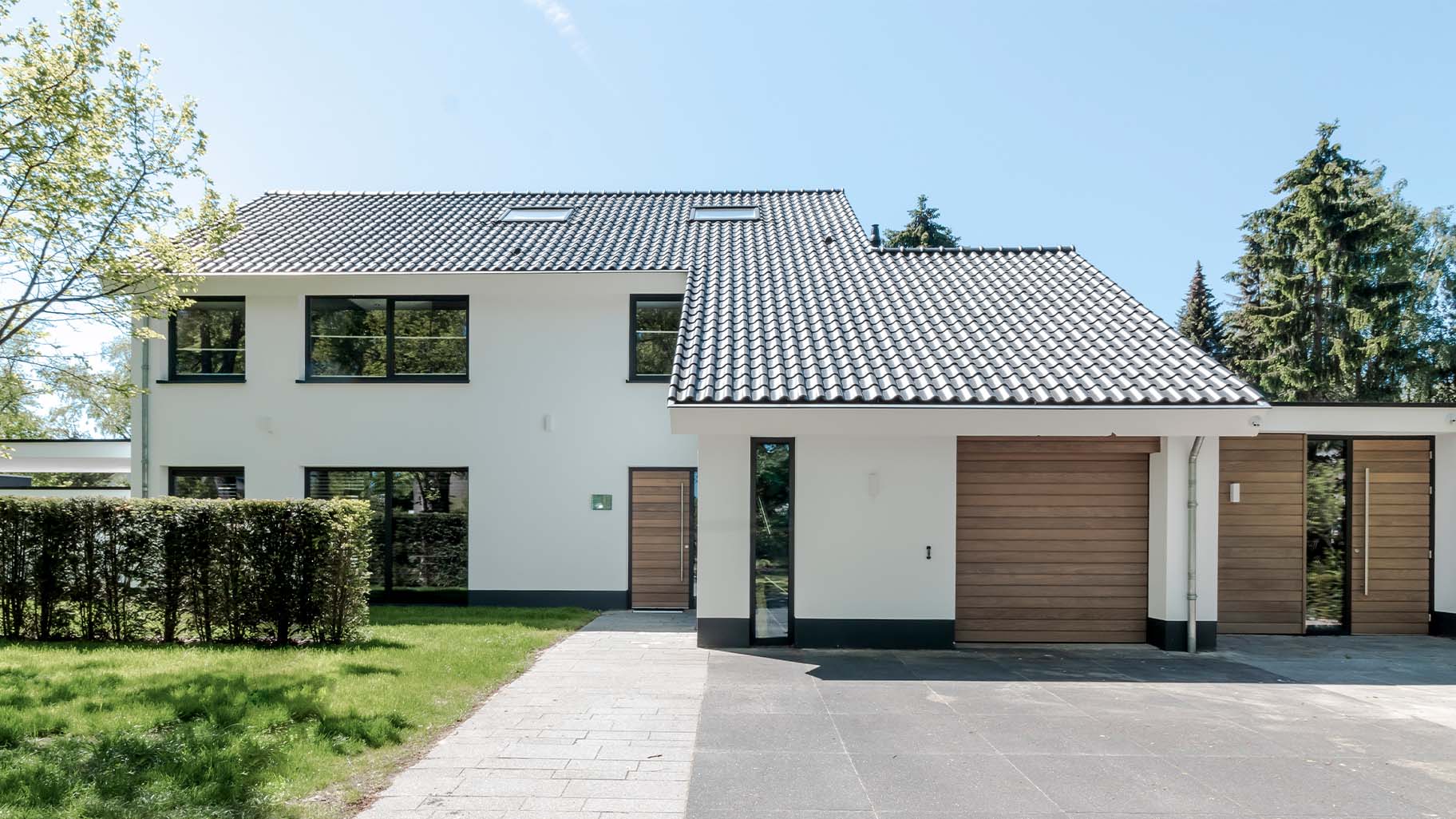 Different Doors houten sectionaaldeur bij gerenoveerde jaren '70 villa