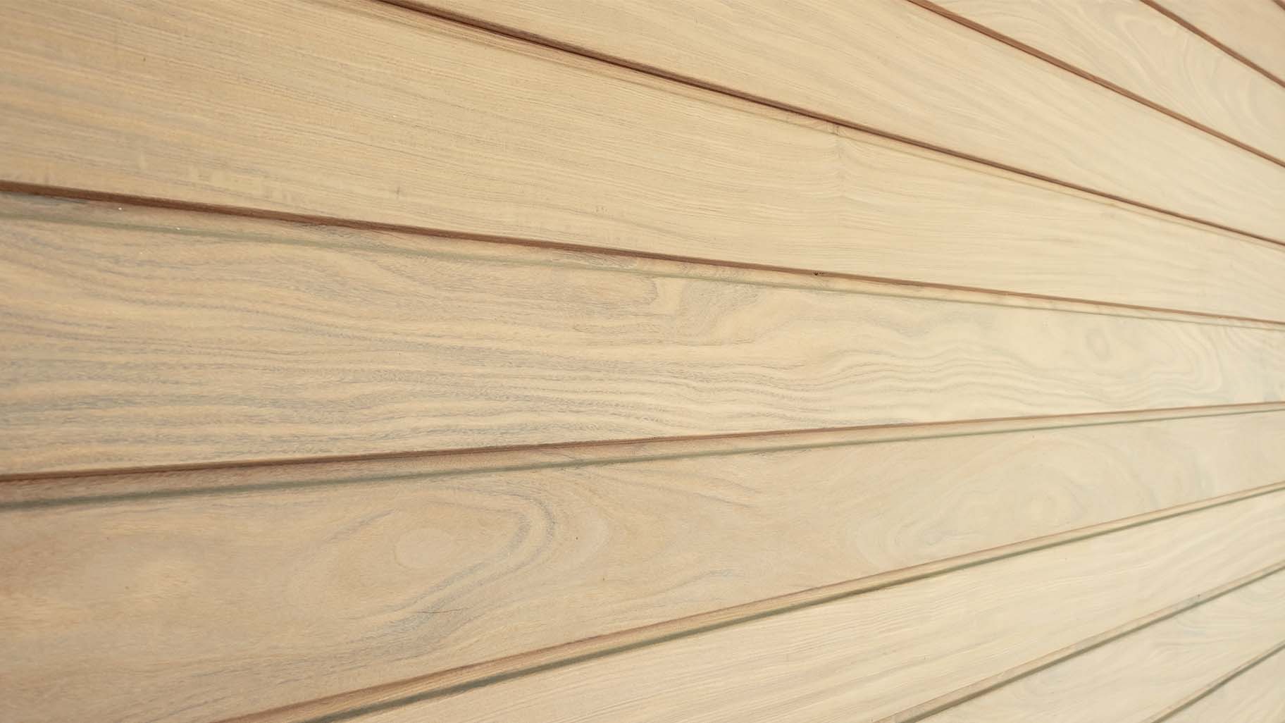 Afrormosia houten planken in garagedeur met rijke bruinrode kleur en opvallende vlamtekening