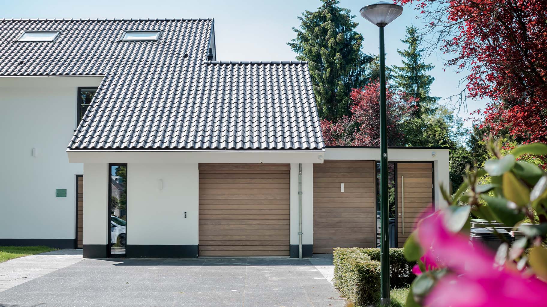 Different Doors houten sectionaaldeur bij gerenoveerde jaren '70 villa