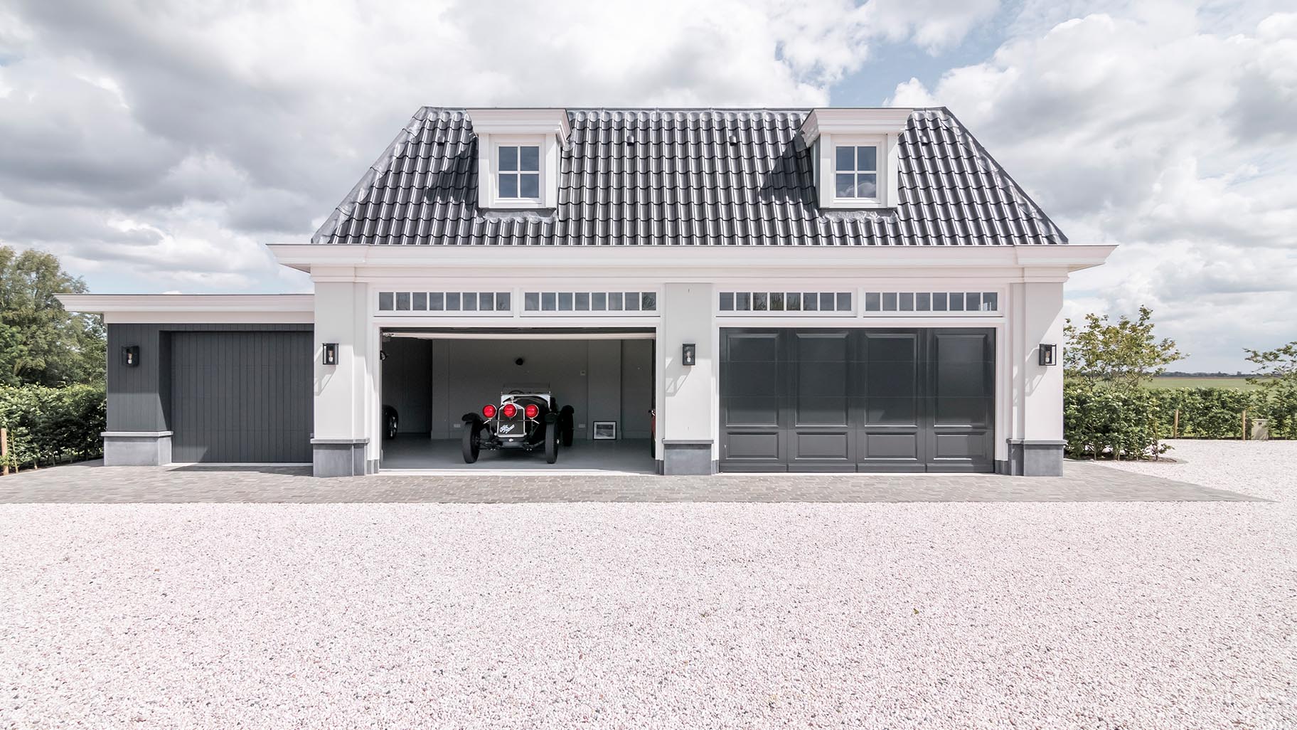 Houten sectionaaldeuren met een klassieke oldtimer geparkeerd in de garage