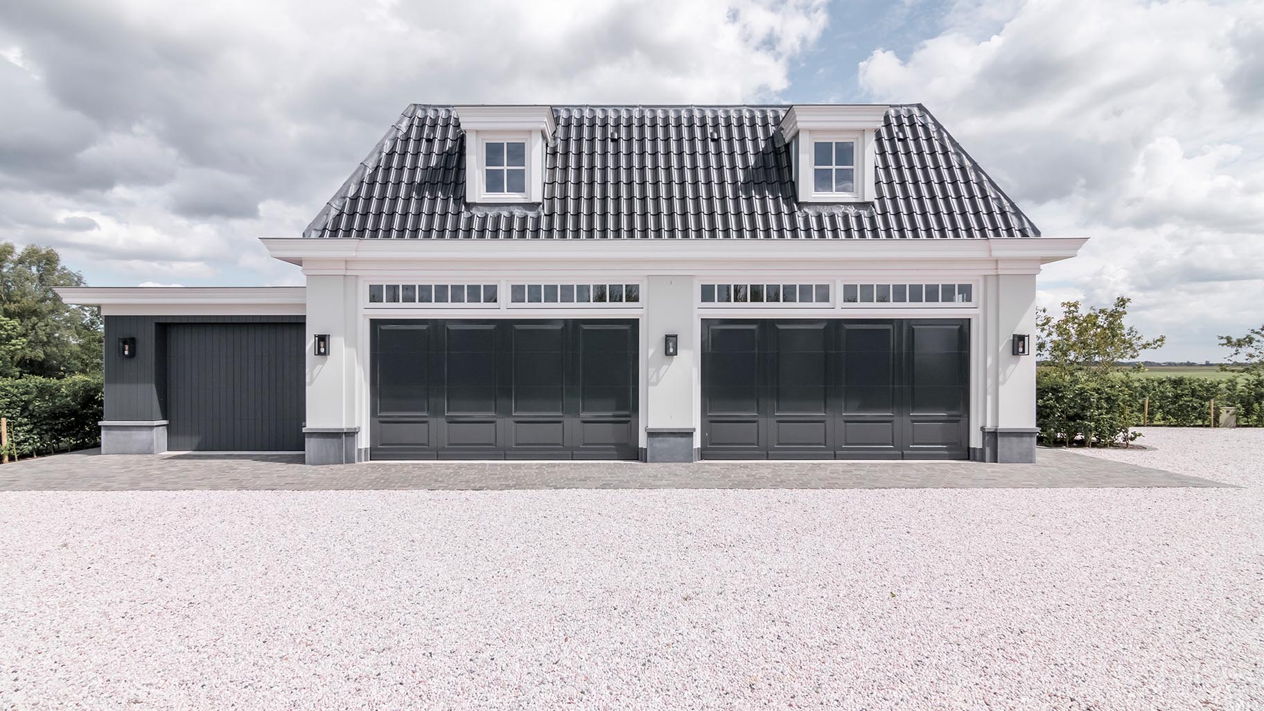Landgoed met villa en garage met drie houten sectionaaldeuren