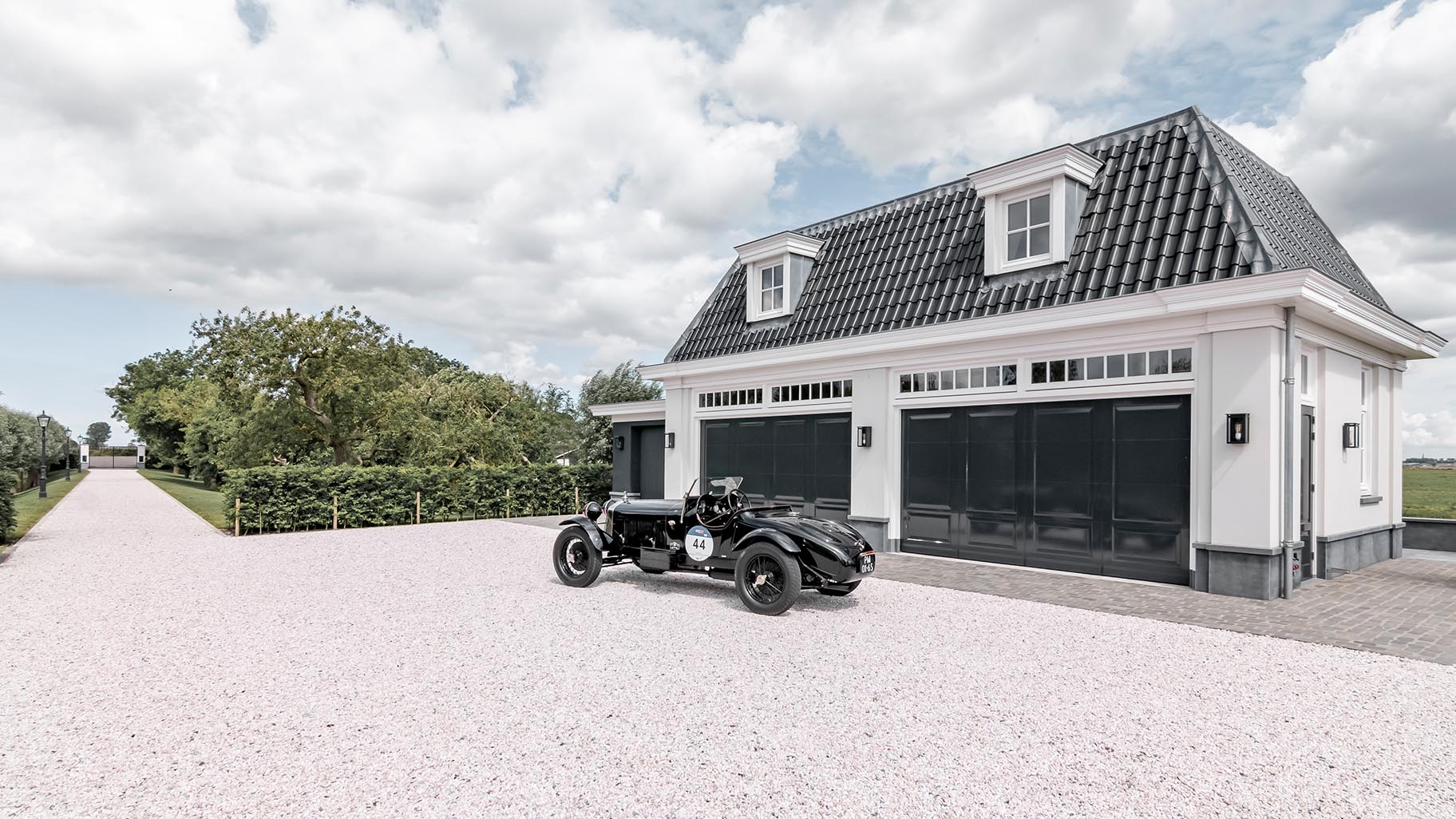 Houten sectionaaldeuren met een klassieke oldtimer geparkeerd in de garage