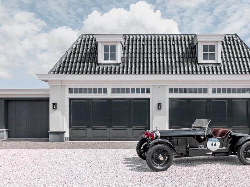 Houten sectionaaldeuren met een klassieke oldtimer geparkeerd in de garage