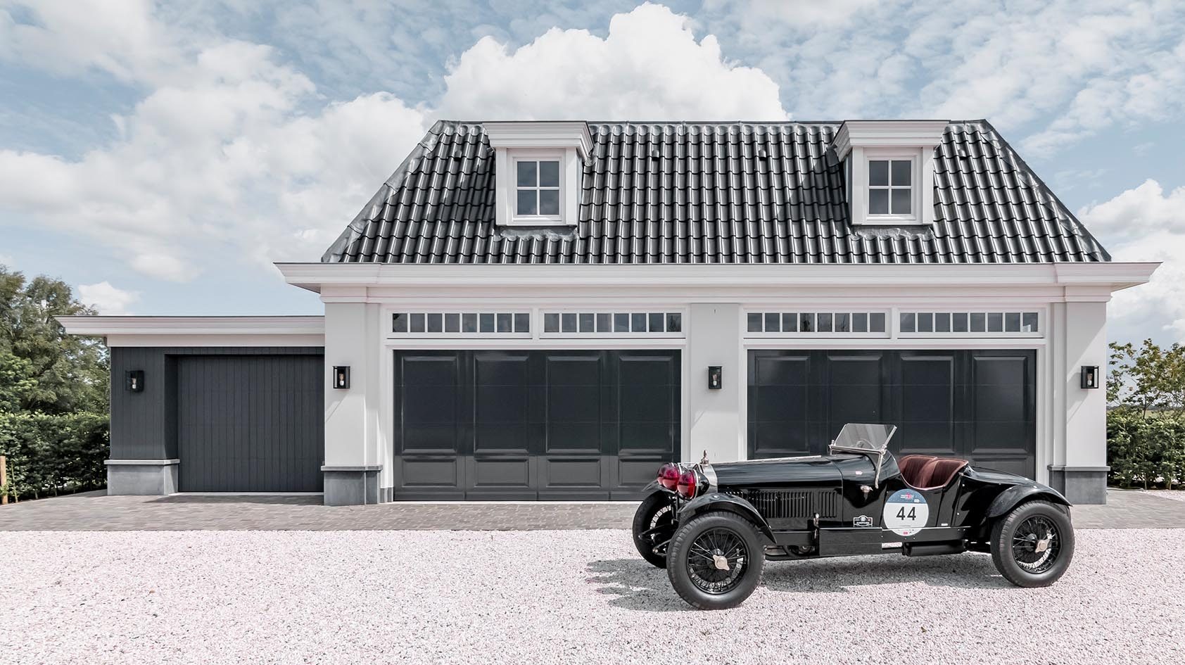 Houten sectionaaldeuren met een klassieke oldtimer geparkeerd in de garage