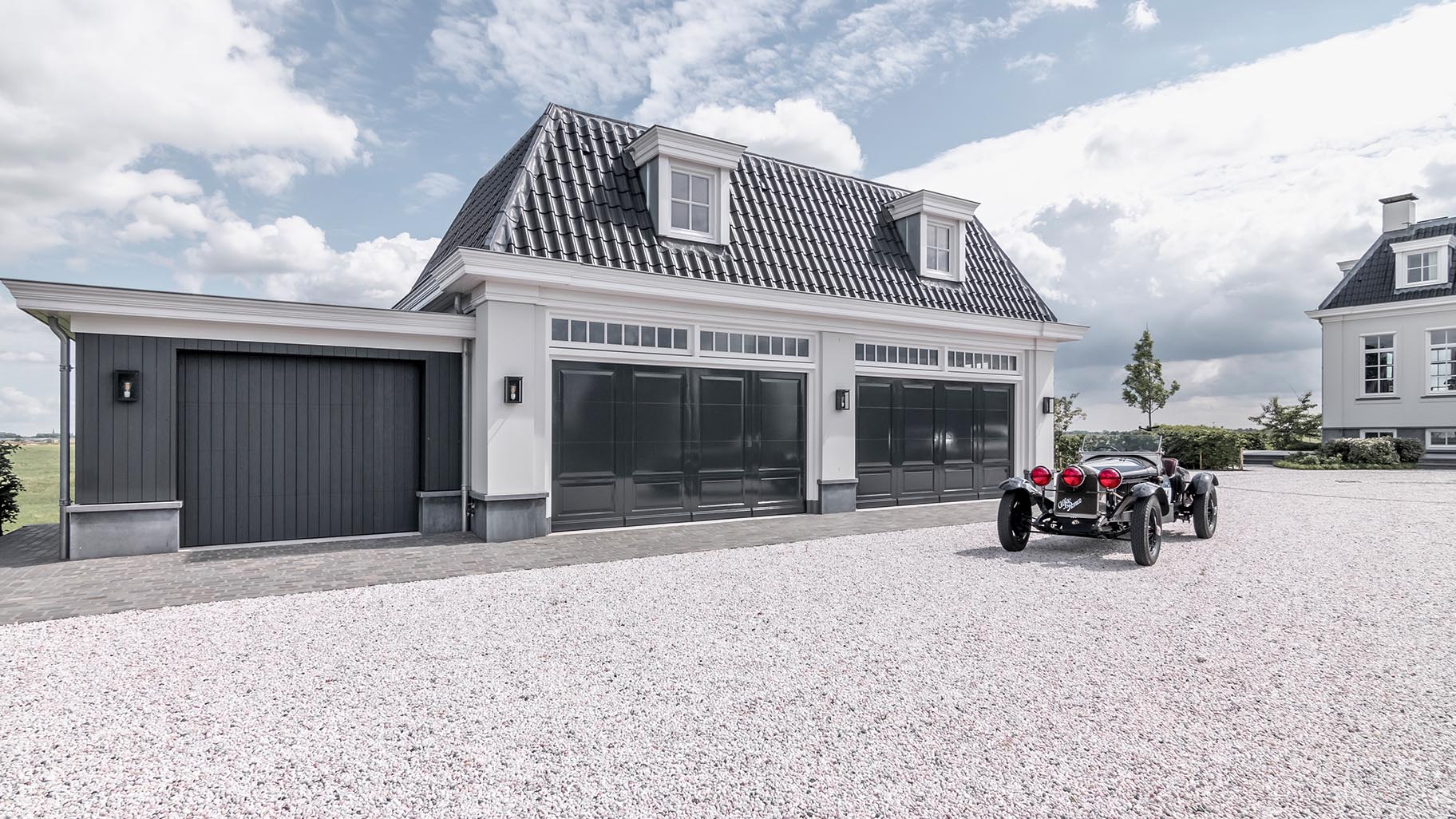 Landgoed met villa en garage met drie houten sectionaaldeuren