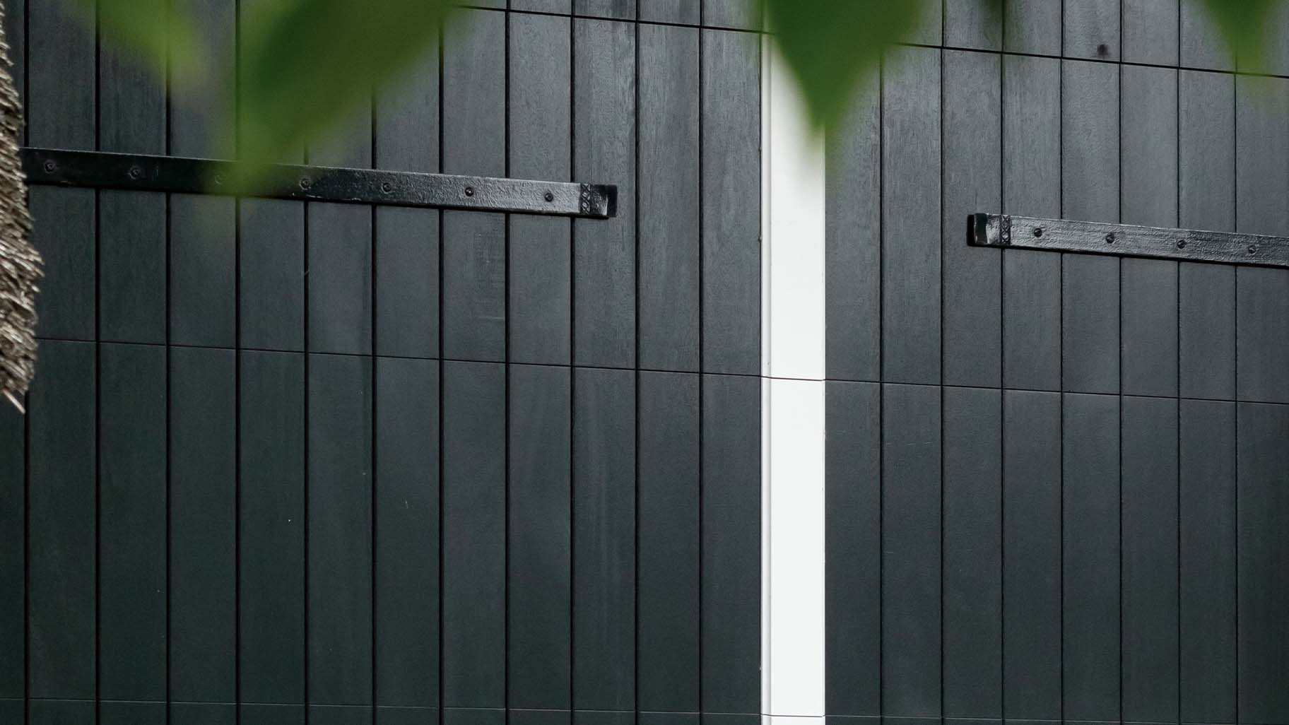 Close-up van houten garagedeur van landelijk huis met donkere houtkleur