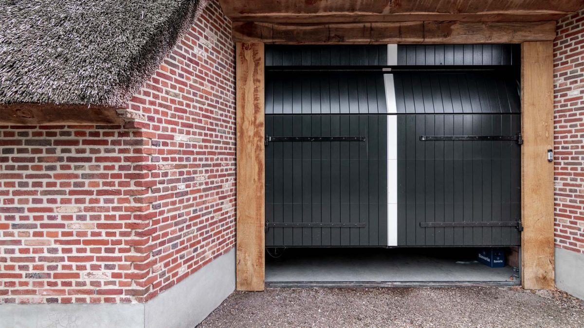 Different Doors houten sectionaaldeur met uitstraling van openslaande garagedeur in boerderijschuur