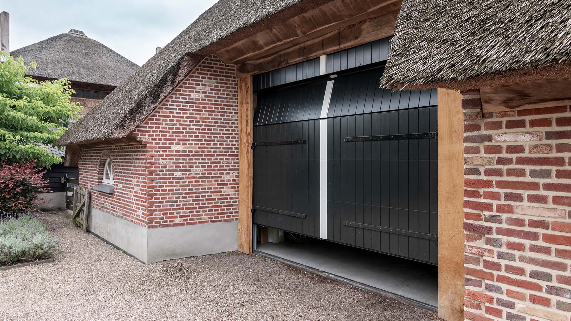 Different Doors houten sectionaaldeur met uitstraling van openslaande garagedeur in boerderijschuur