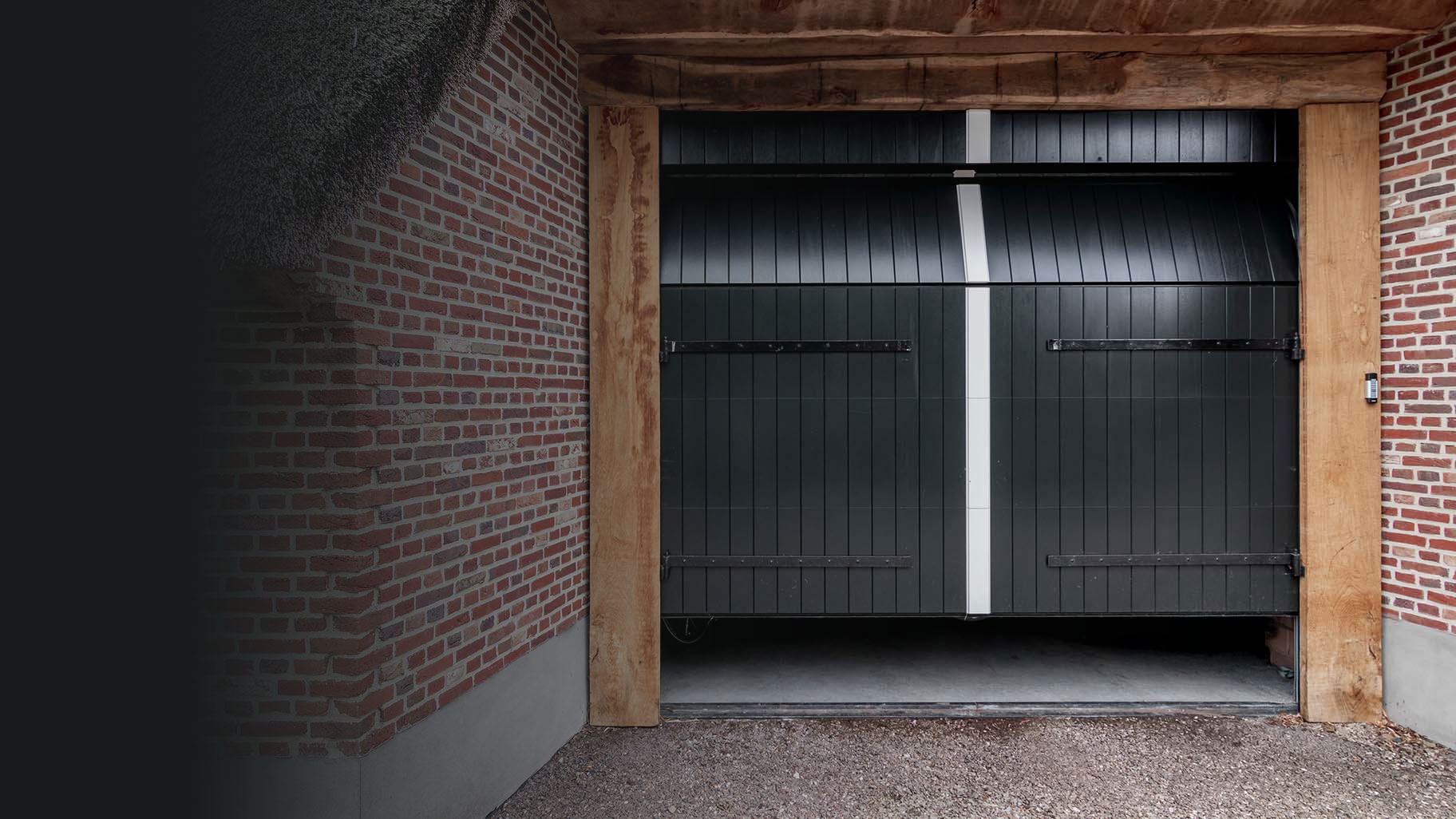 Boerderij met rieten dak en houten sectionaal garagedeur, passend bij landelijke uitstraling