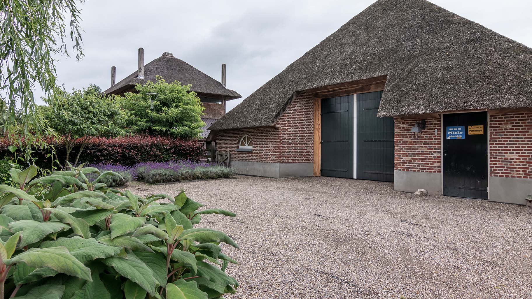 Different Doors houten sectionaaldeur met uitstraling van openslaande garagedeur in boerderijschuur