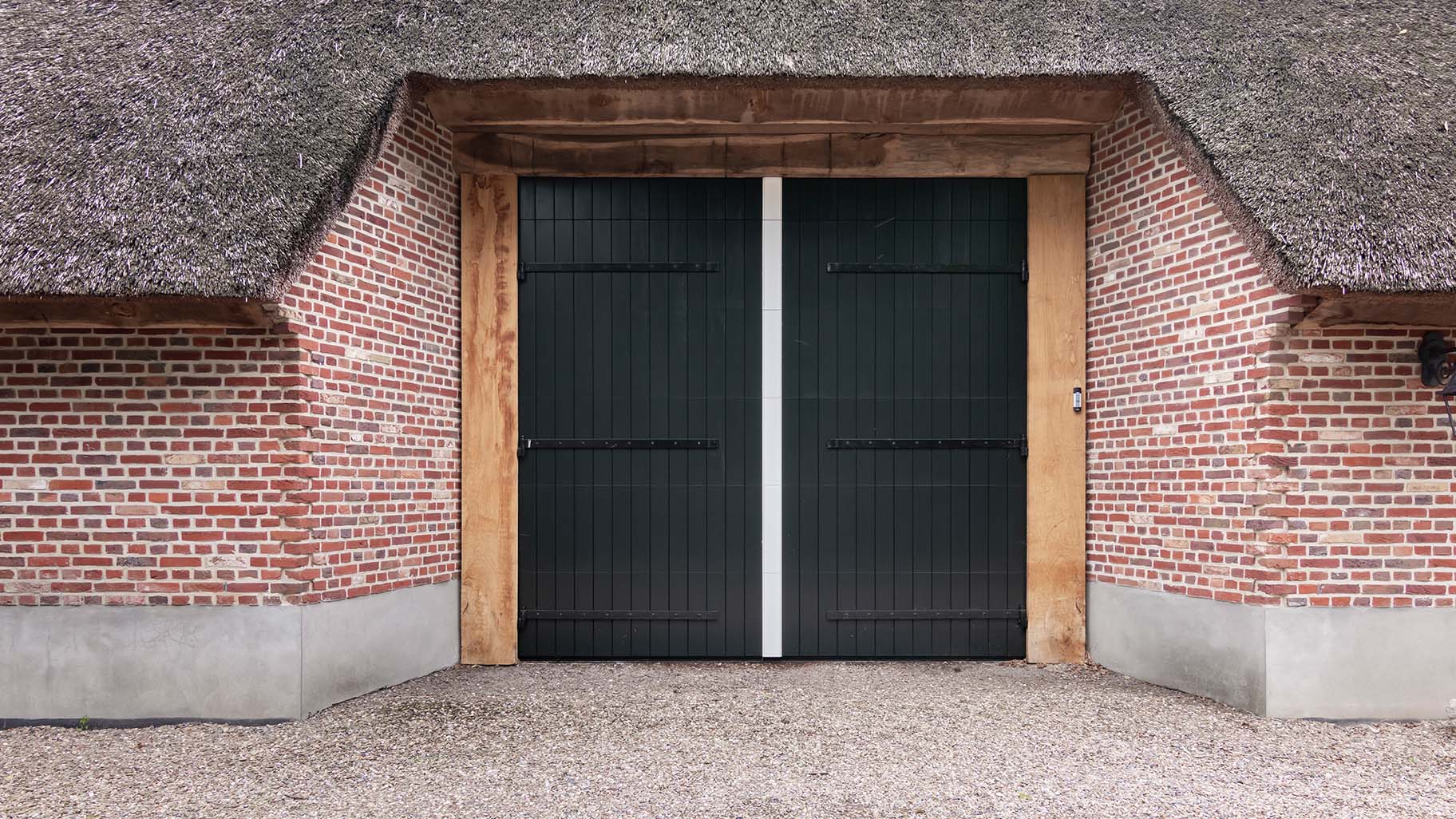 Different Doors houten sectionaaldeur met uitstraling van openslaande garagedeur in boerderijschuur