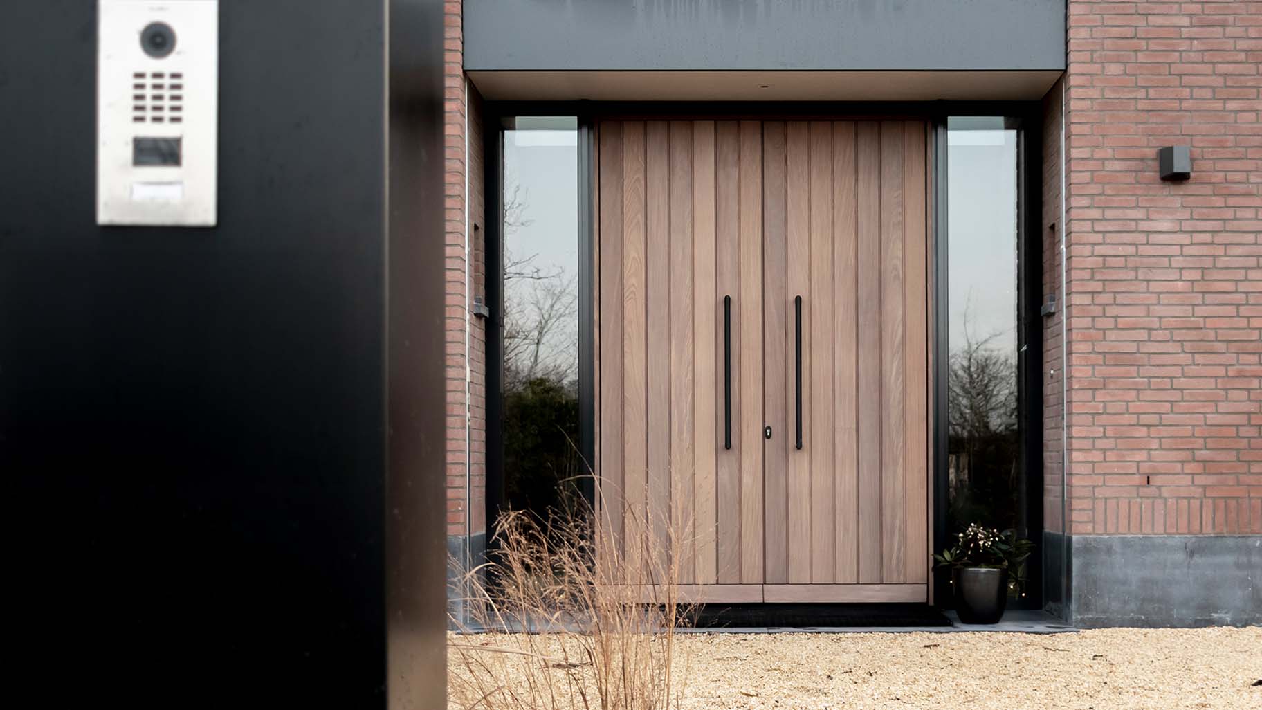 Moderne villa met Afrormosia houten deuren, passend bij de gevel en woning