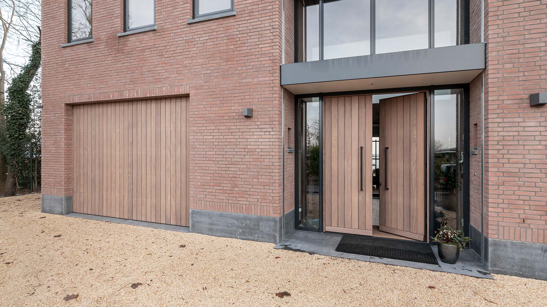 Different Doors Afrormosia houten garagedeur en dubbele voordeur in aluminium kozijn
