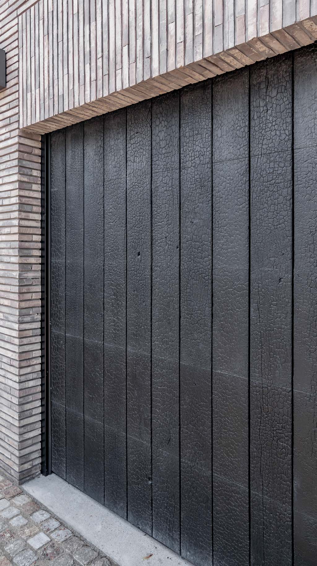 Shou Sugi Ban houten garagedeur, met de traditionele Japanse verbrandingstechniek voor een diepe zwarte kleur en unieke textuur