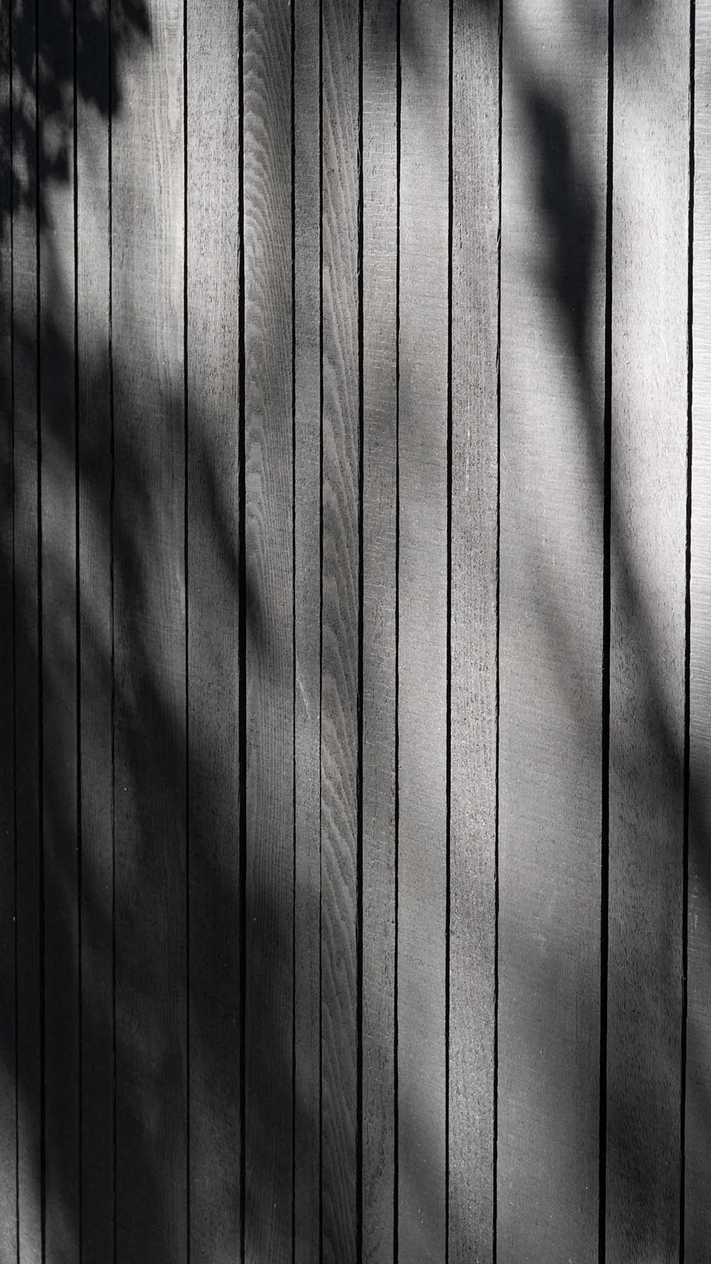 Donkere houten garagedeur van red cedar hout gerealiseerd door different doors