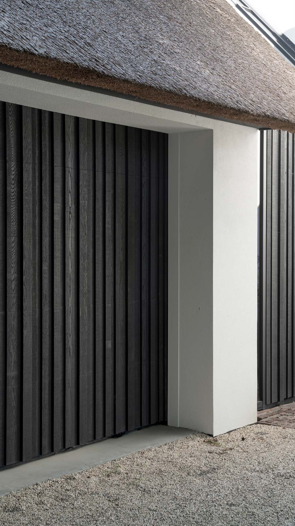 Donkere houten garagedeur van red cedar hout gerealiseerd door different doors