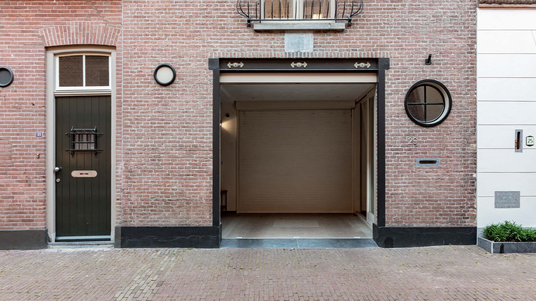 Monumentaal pand met donkere zwarte garagedeur