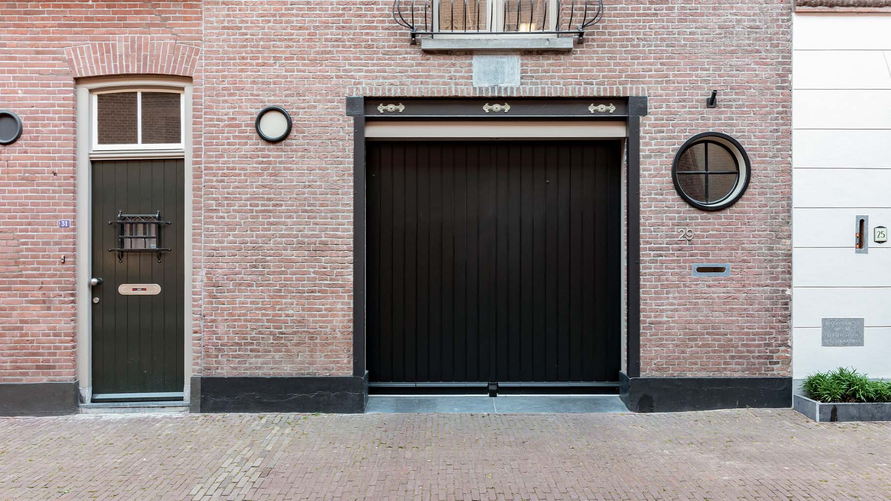 Monumentaal pand met donkere zwarte garagedeur