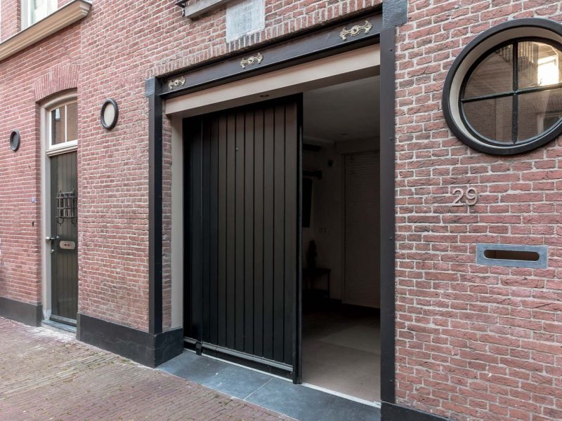 Monumentaal pand met donkere zwarte garagedeur