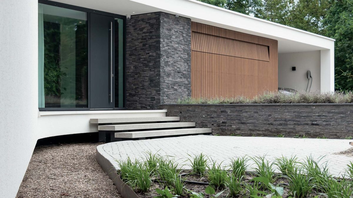 houten sectionaaldeur met verticale latten in warme bruintinten, passend bij de gevelbekleding