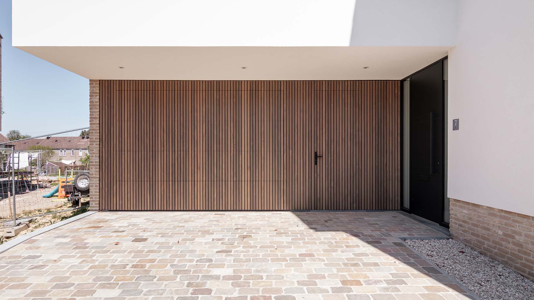 Houten sectionaaldeur en loopdeur van afrormosia hout gemaakt door different doors