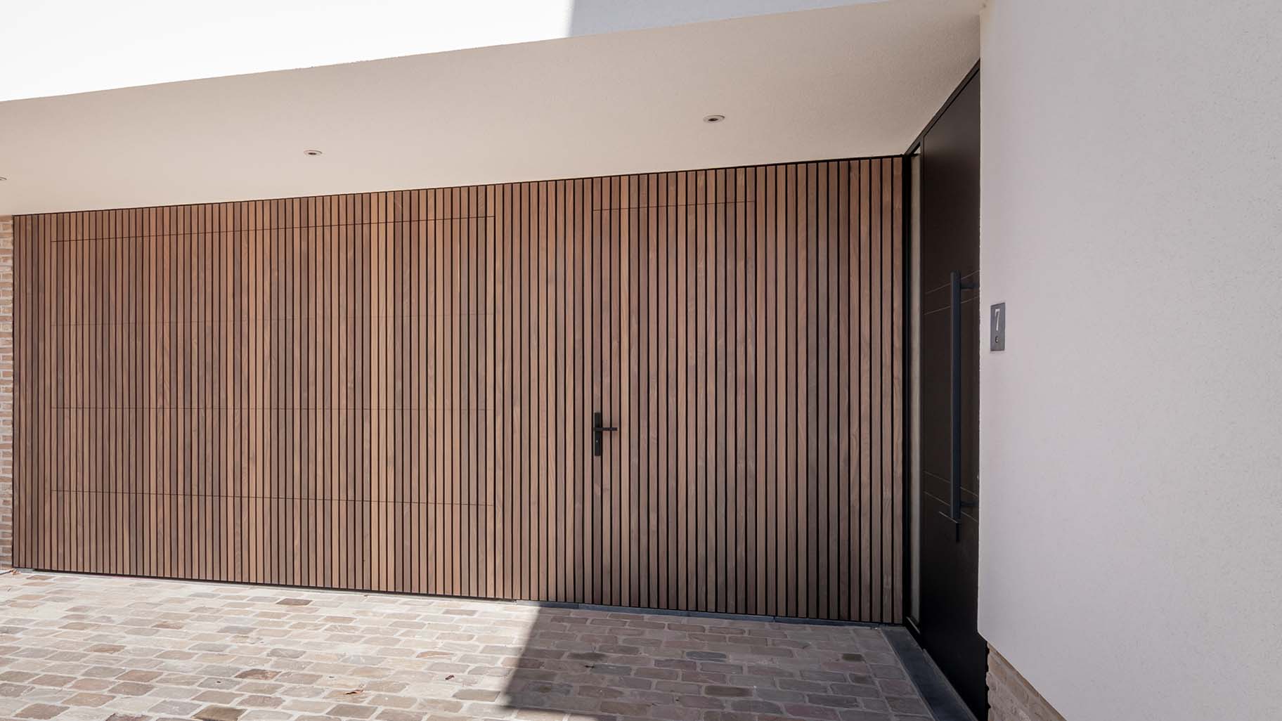 Houten sectionaaldeur en loopdeur van afrormosia hout gemaakt door different doors