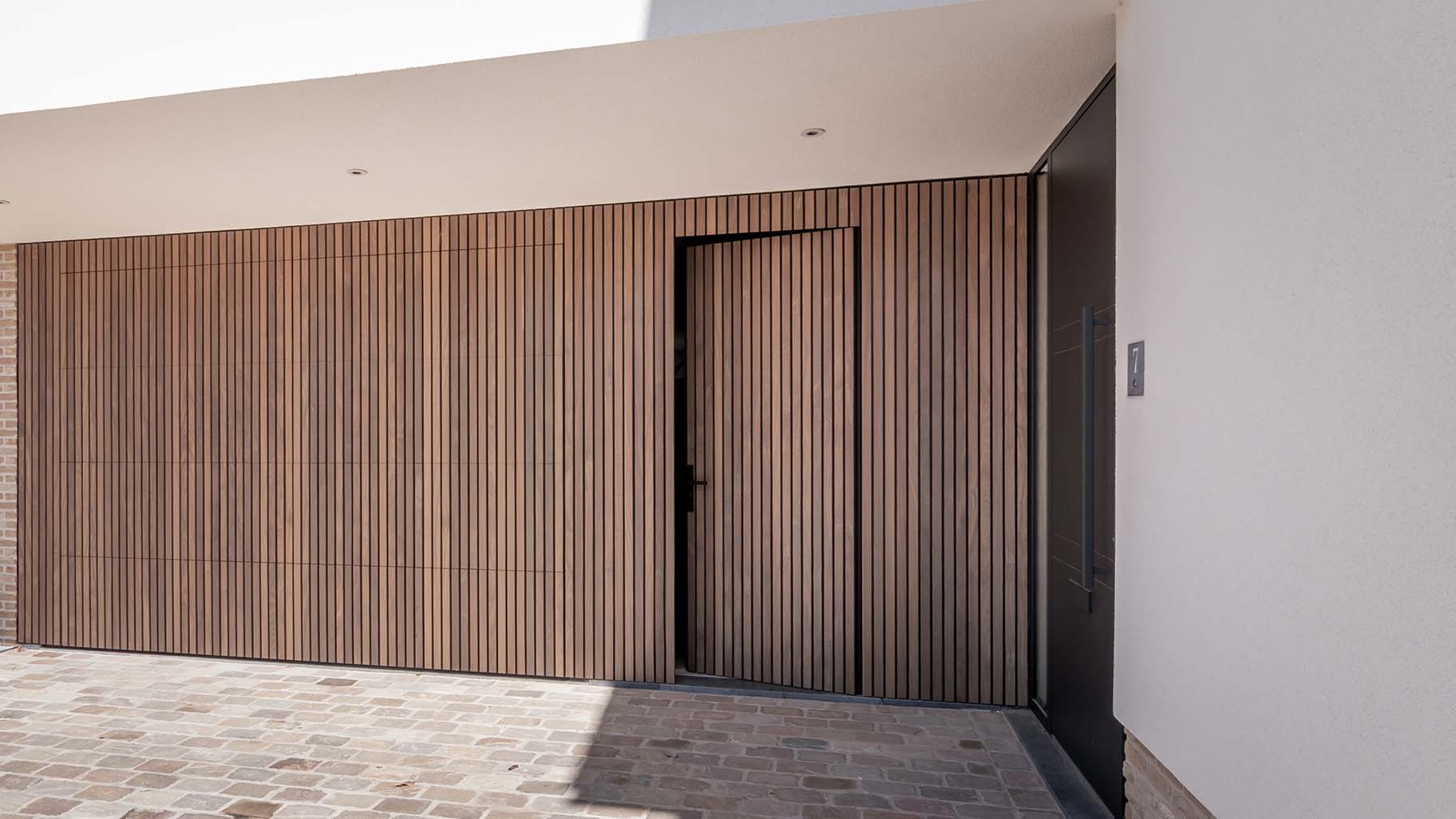 Houten sectionaaldeur en loopdeur van afrormosia hout gemaakt door different doors