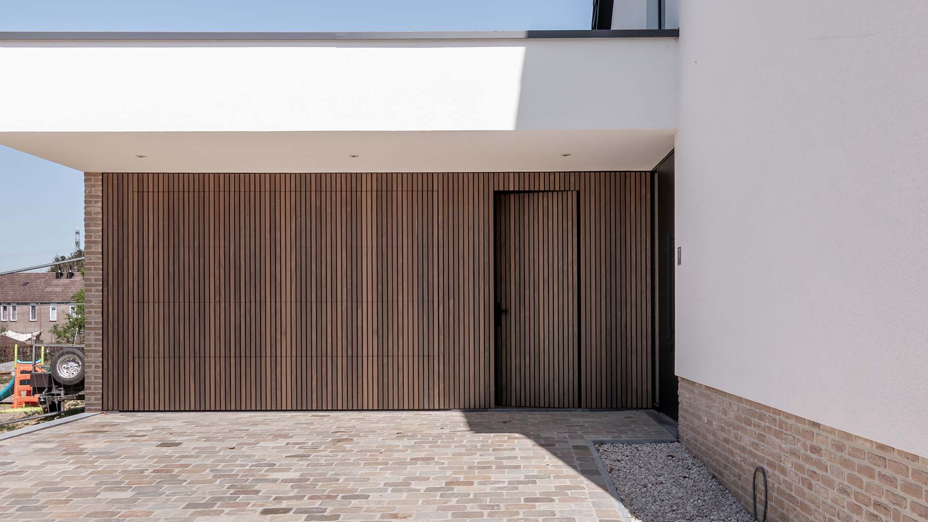 Houten sectionaaldeur en loopdeur van afrormosia hout gemaakt door different doors