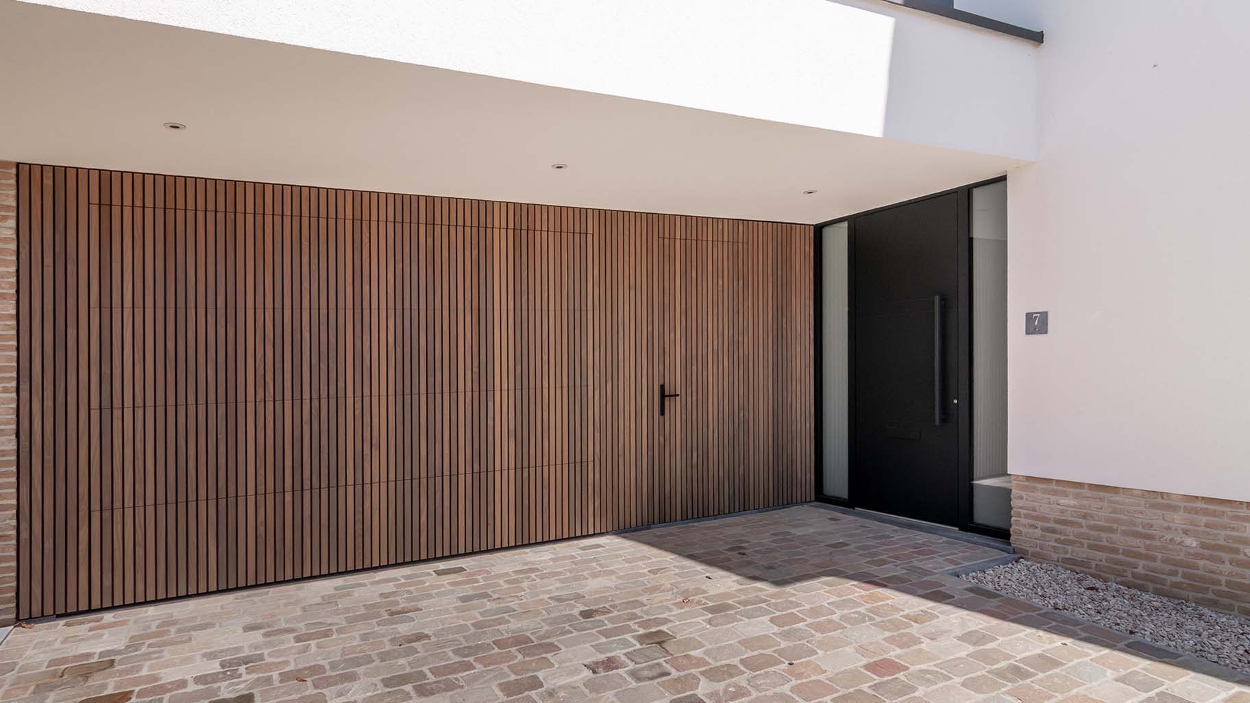 Houten sectionaaldeur en loopdeur van afrormosia hout gemaakt door different doors