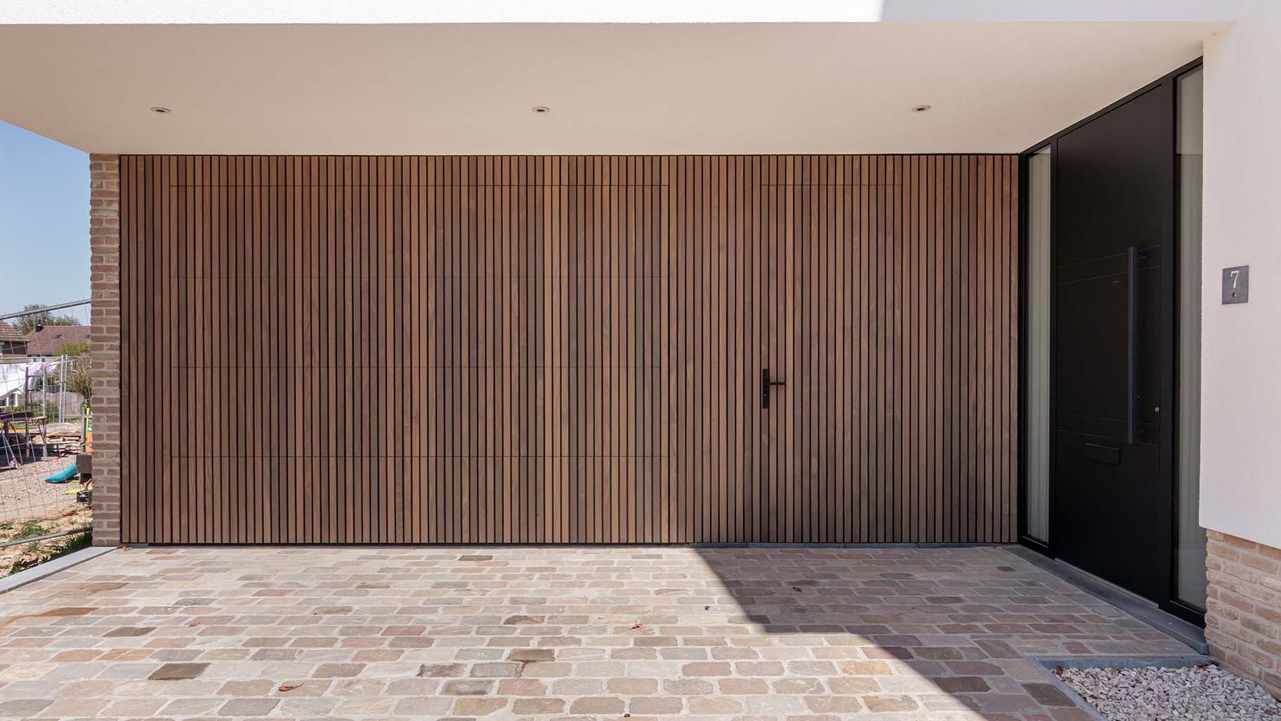 Houten sectionaaldeur en loopdeur van afrormosia hout gemaakt door different doors