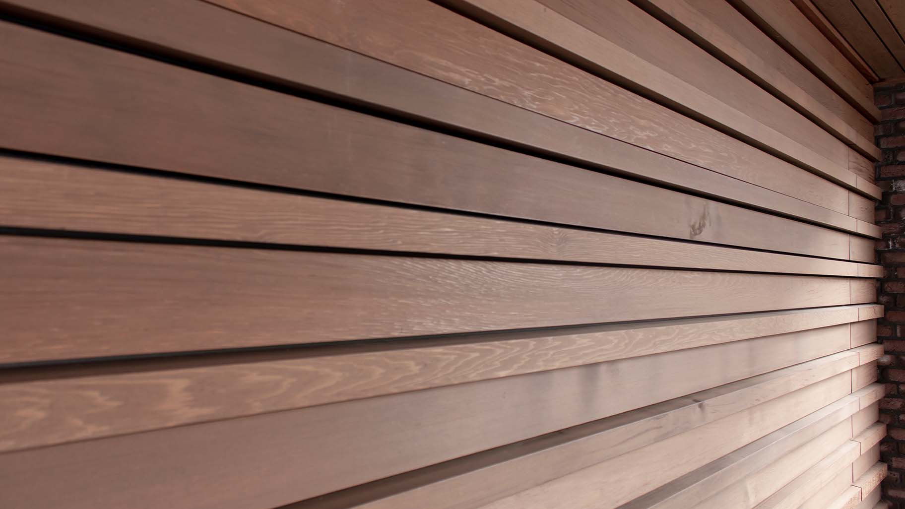 Houten sectionaaldeur bekleed met Red Cedar latten gerealiseerd door different doors