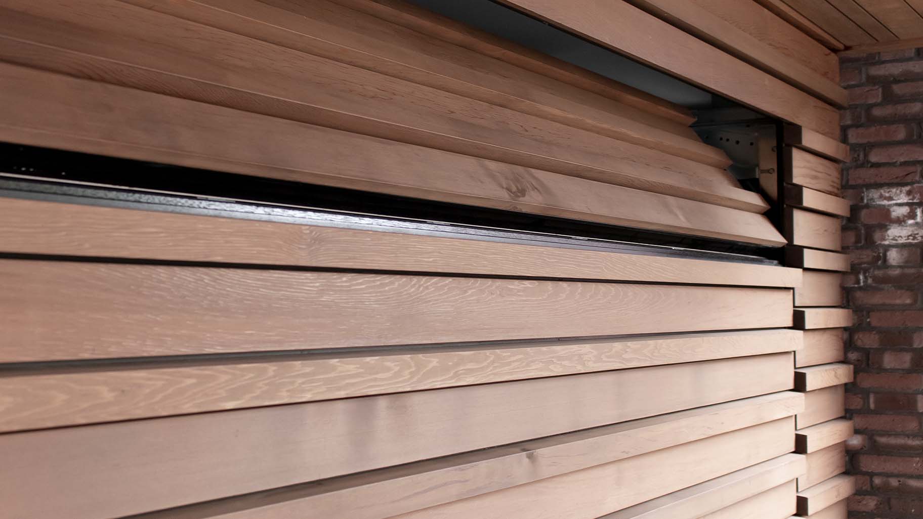 Houten sectionaaldeur bekleed met Red Cedar latten gerealiseerd door different doors
