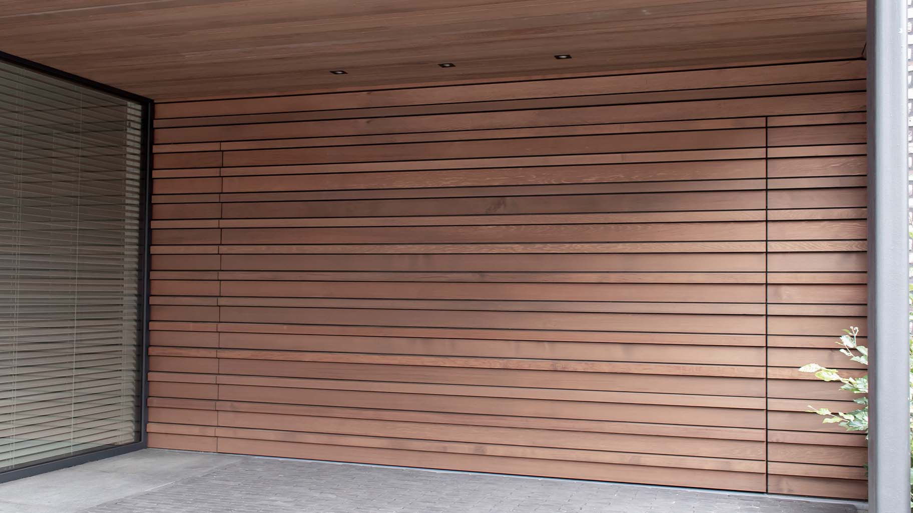 Houten sectionaaldeur bekleed met Red Cedar latten gerealiseerd door different doors