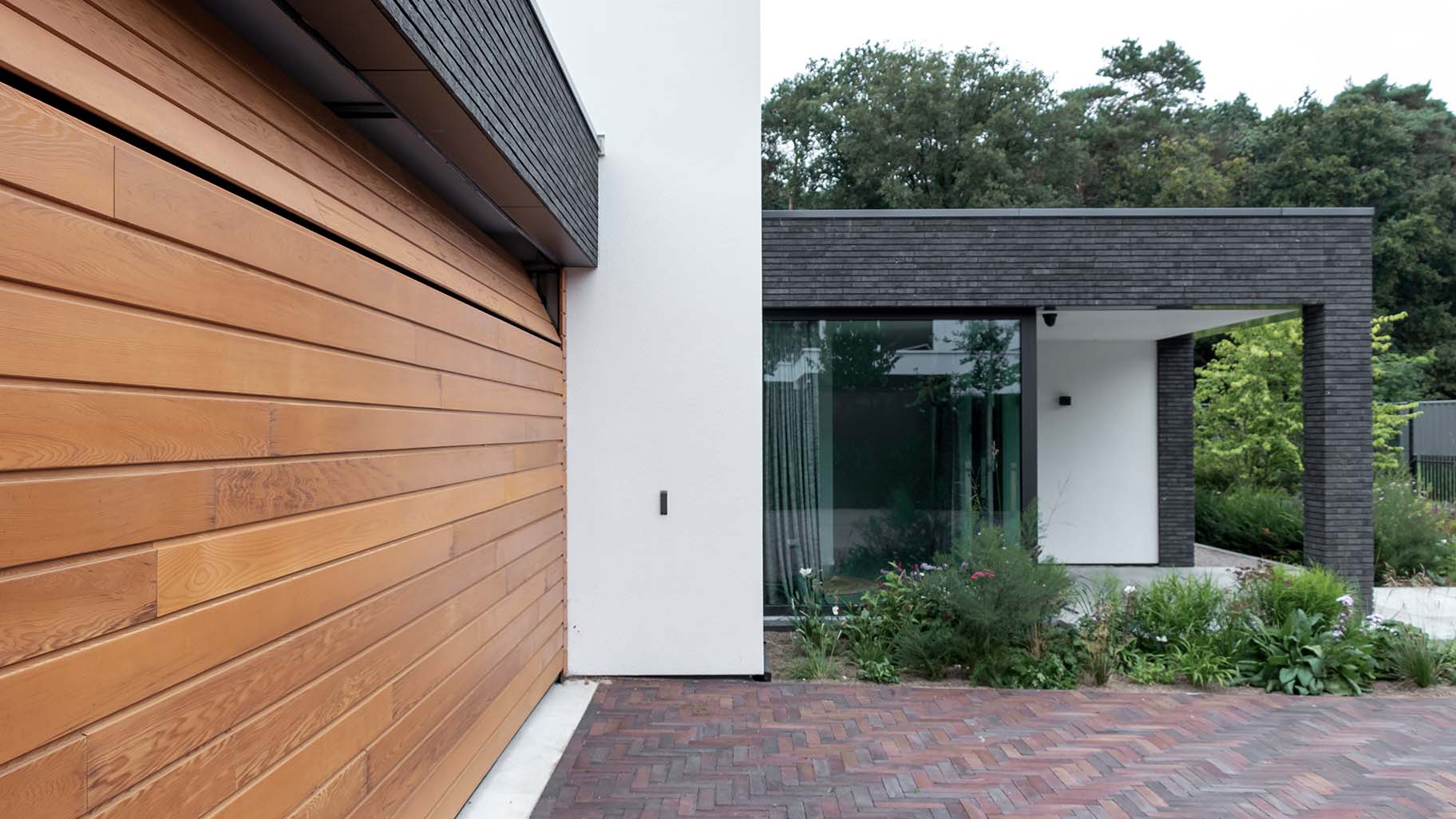 Houten sectionaaldeur van Red Cedar hout bij witte villa