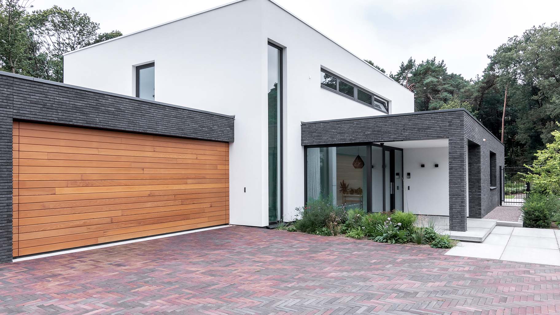 Houten sectionaaldeur van Red Cedar hout bij witte villa