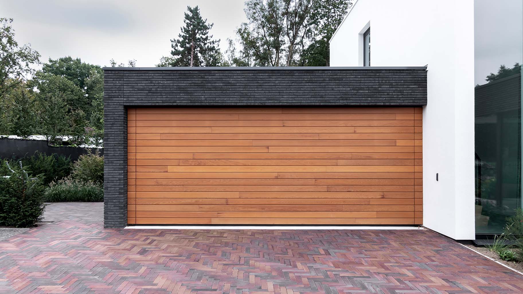 Houten sectionaaldeur van Red Cedar hout bij witte villa