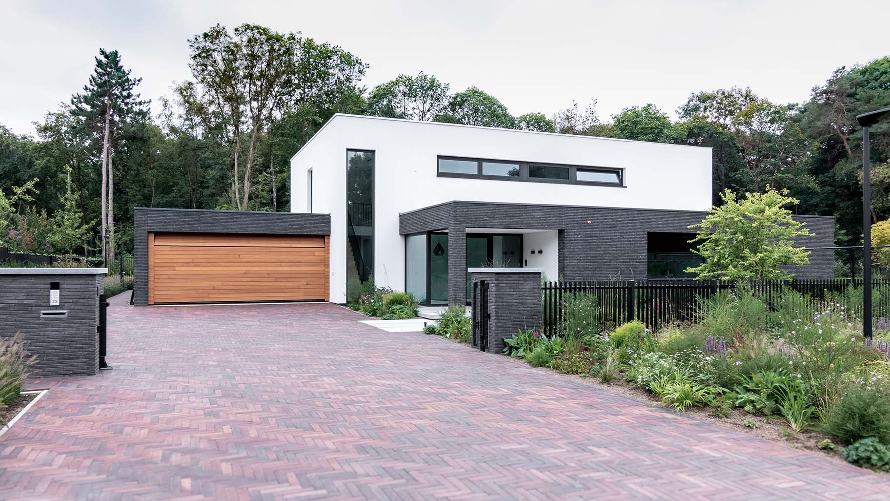 Houten sectionaaldeur van Red Cedar hout bij witte villa