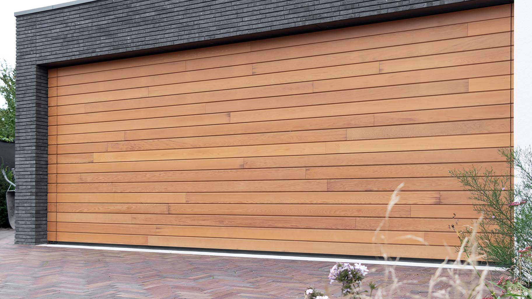 Houten sectionaaldeur van Red Cedar hout bij witte villa