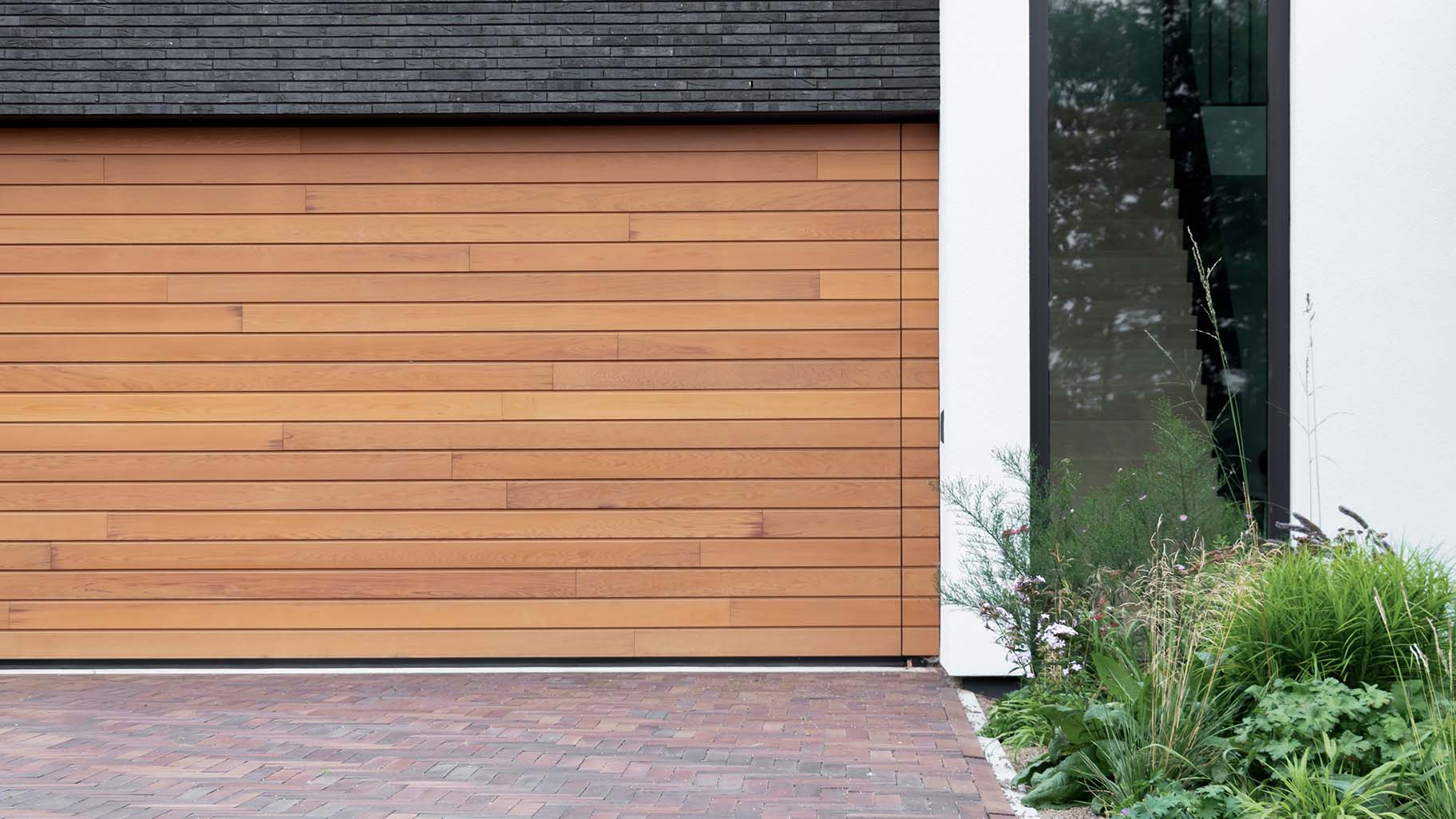 Houten sectionaaldeur van Red Cedar hout bij witte villa