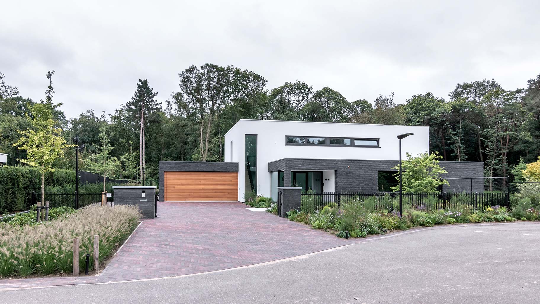 Houten sectionaaldeur van Red Cedar hout bij witte villa