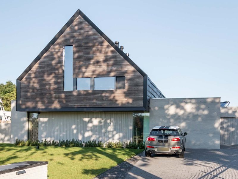 Woning met een houten taatsdeur als voordeur en een houten garagedeur