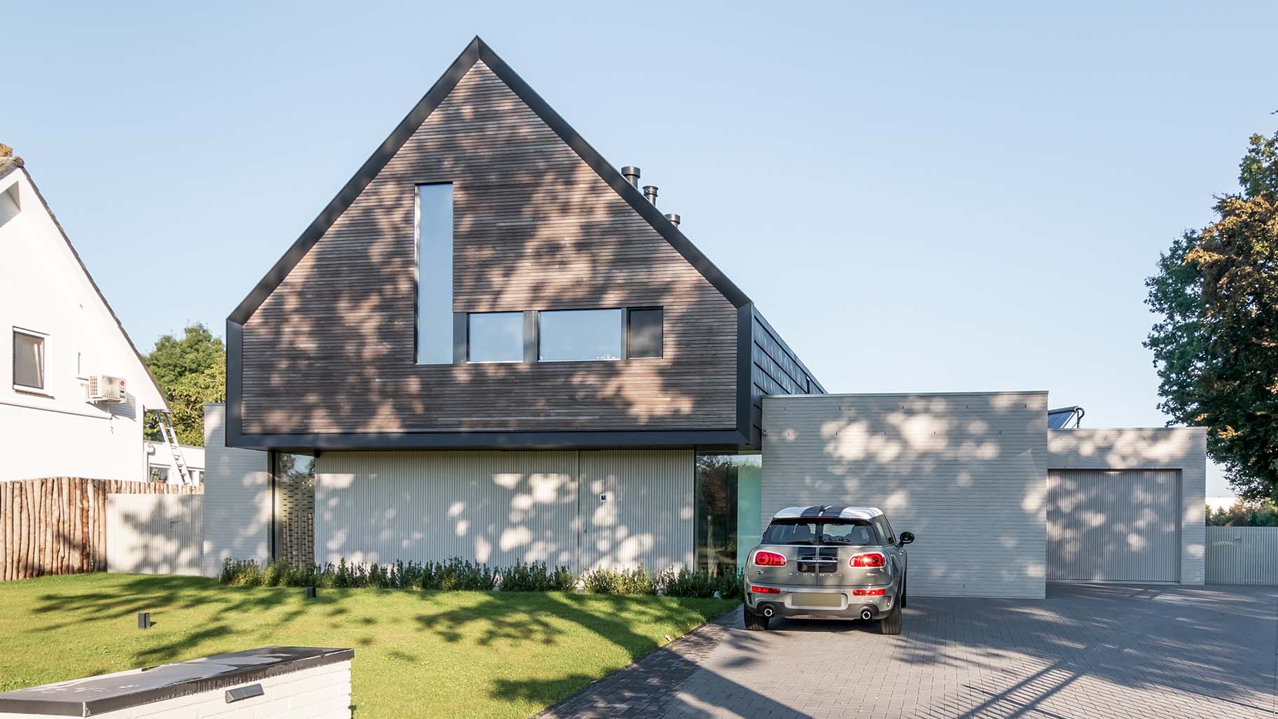 Woning met een houten taatsdeur als voordeur en een houten garagedeur