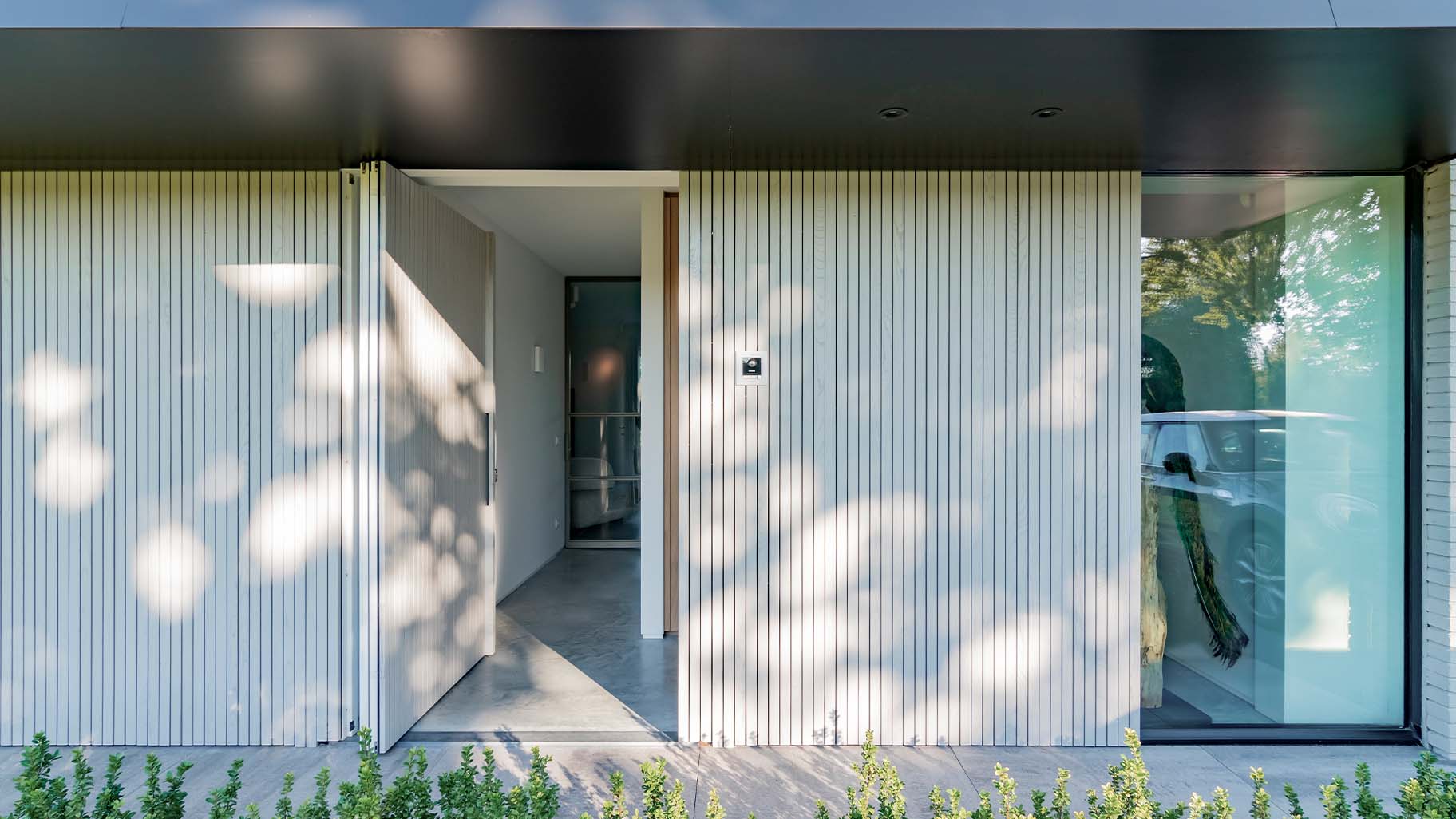 Woning met een houten taatsdeur als voordeur en een houten garagedeur